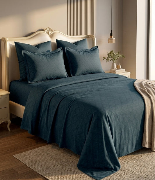 Bed with teal bedding and pillows in a bedroom setting