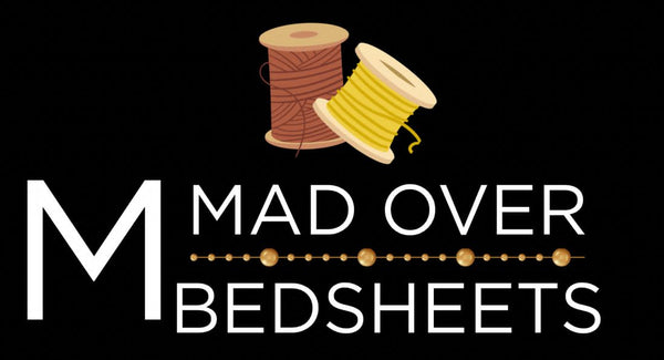 Logo for 'Mad Over Bedsheets' with spools of thread on a black background