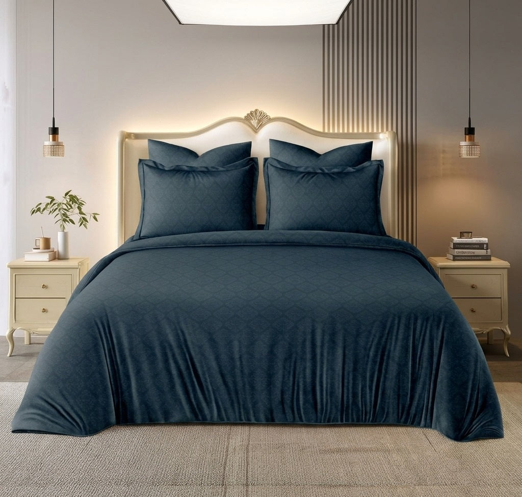 Bedroom with a bed covered in dark blue bedding, two nightstands with lamps, and decorative elements.