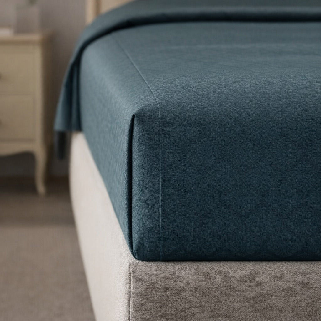 Teal fitted sheet on a bed in a bedroom setting