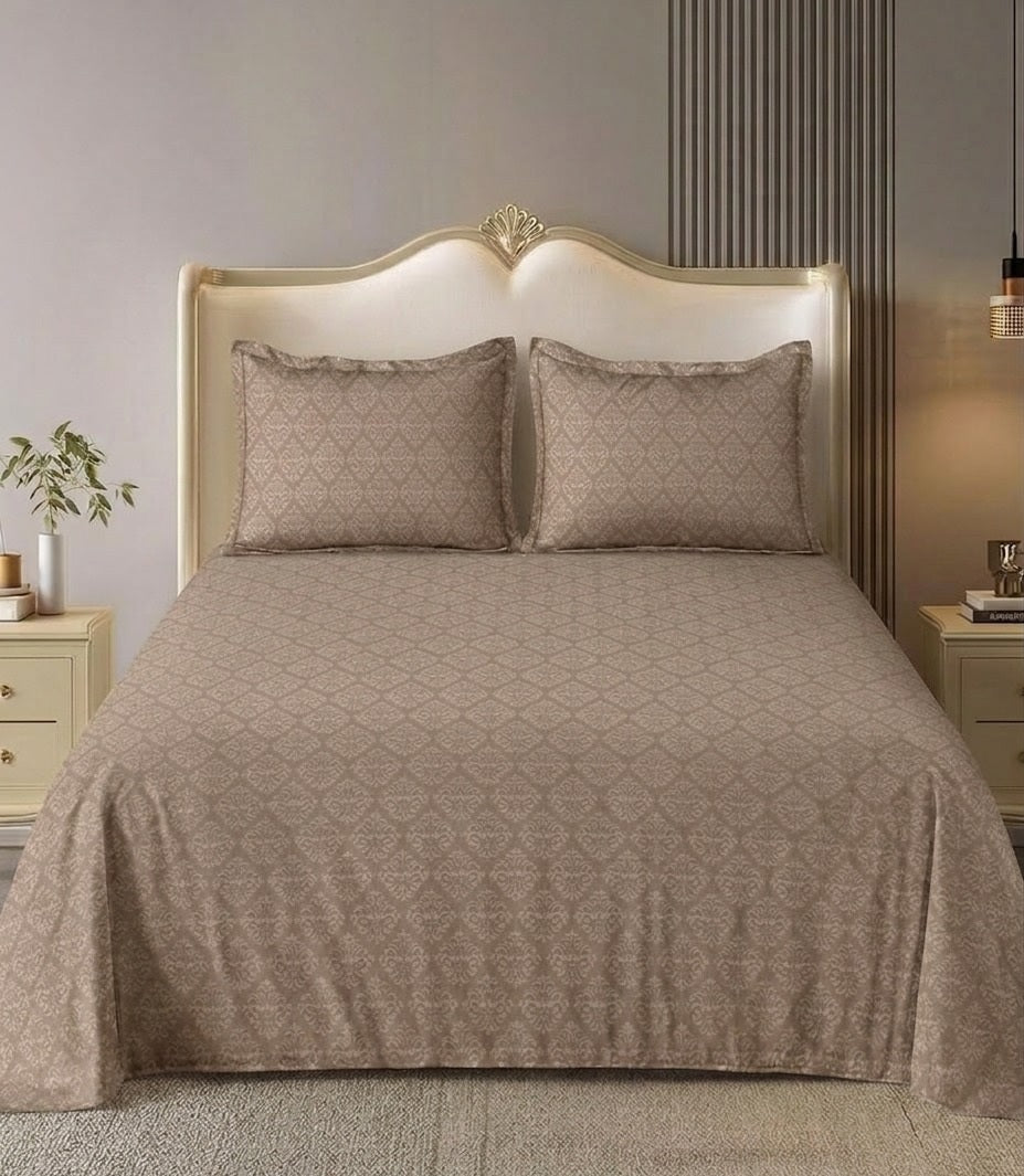 Bed with beige quilt and pillows in a bedroom setting