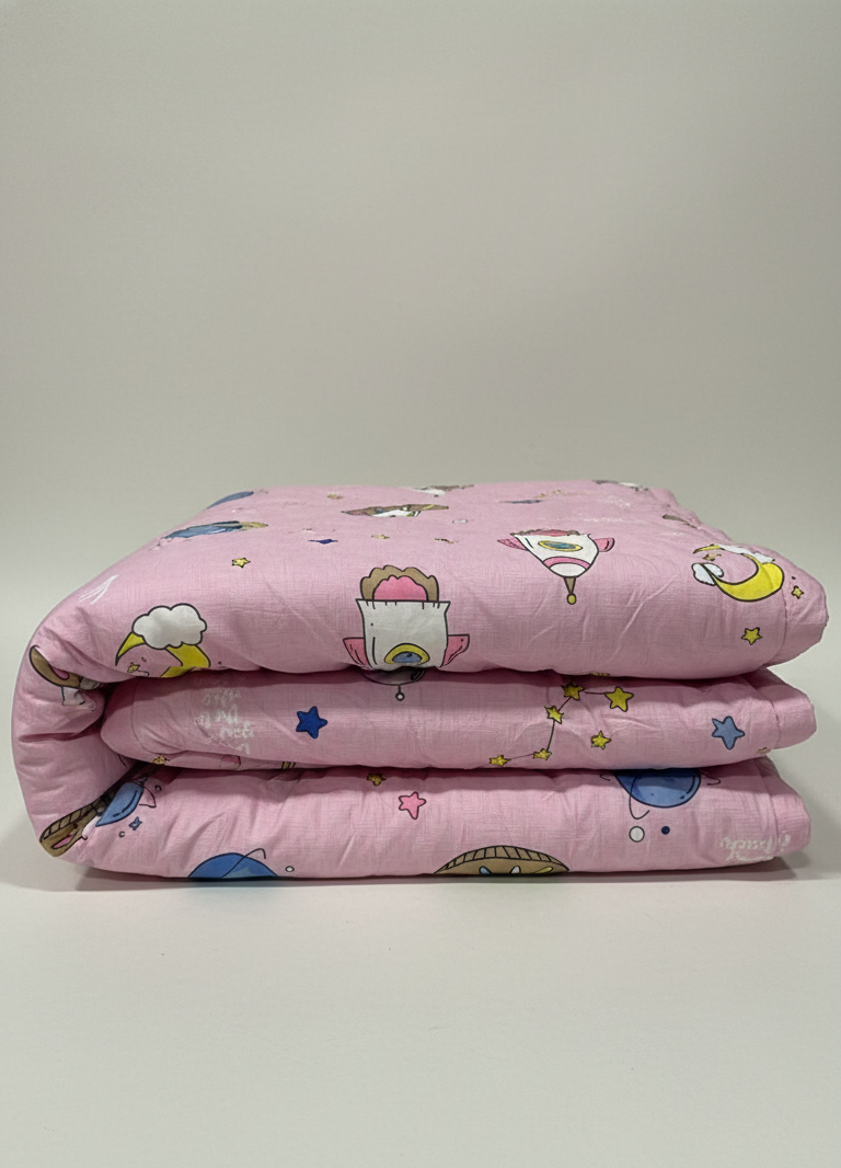 Pink quilt with cartoon patterns on a light gray background