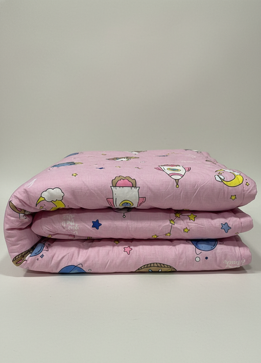 Pink quilt with cartoon patterns on a light gray background