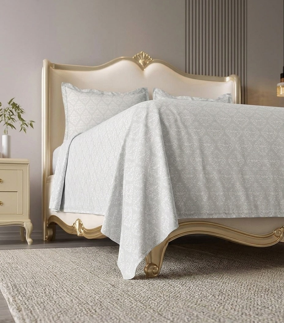 Bed with white bedding and decorative headboard in a bedroom setting