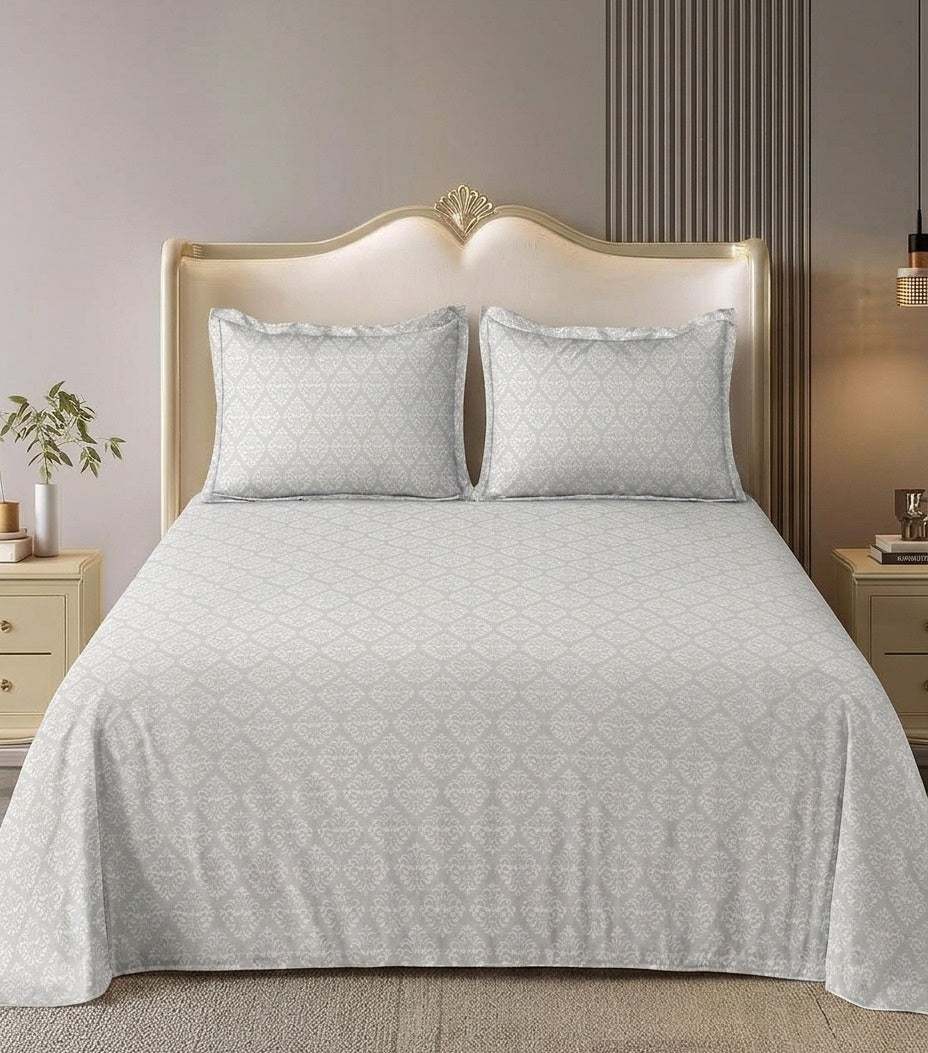 Gray bedsheet with matching pillows in a bedroom setting.