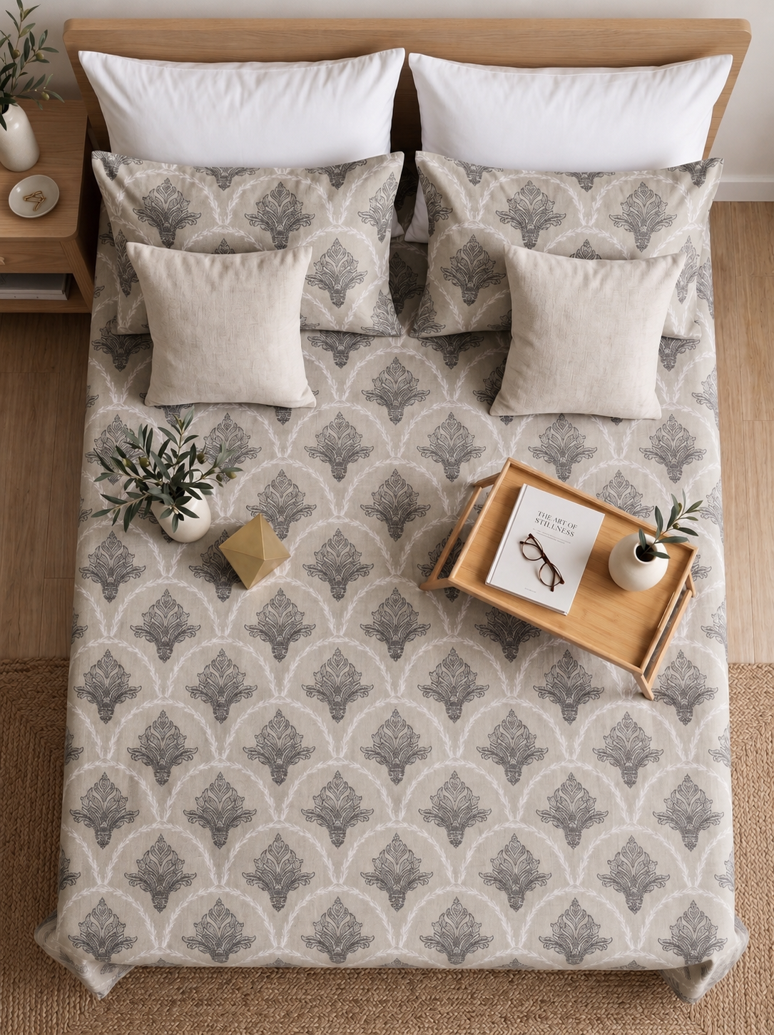 Bed with patterned bedding, pillows, and a wooden nightstand.